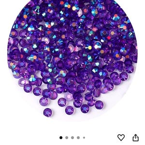 Puede incluir: Una colecci&oacute;n de pedrer&iacute;a AB transparente de color p&uacute;rpura oscuro. La pedrer&iacute;a es redonda y facetada, con un efecto brillante e iridiscente. El color se describe como Clear Dark Purple AB.