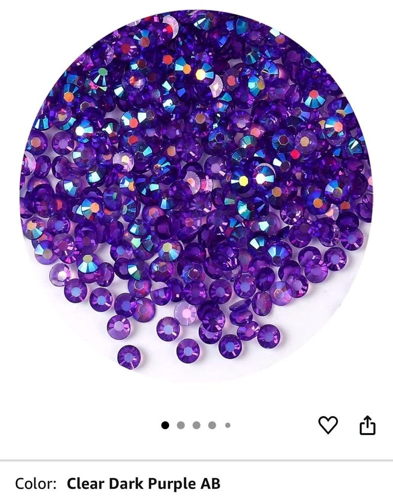 Puede incluir: Una colecci&oacute;n de pedrer&iacute;a AB transparente de color p&uacute;rpura oscuro. La pedrer&iacute;a es redonda y facetada, con un efecto brillante e iridiscente. El color se describe como Clear Dark Purple AB.