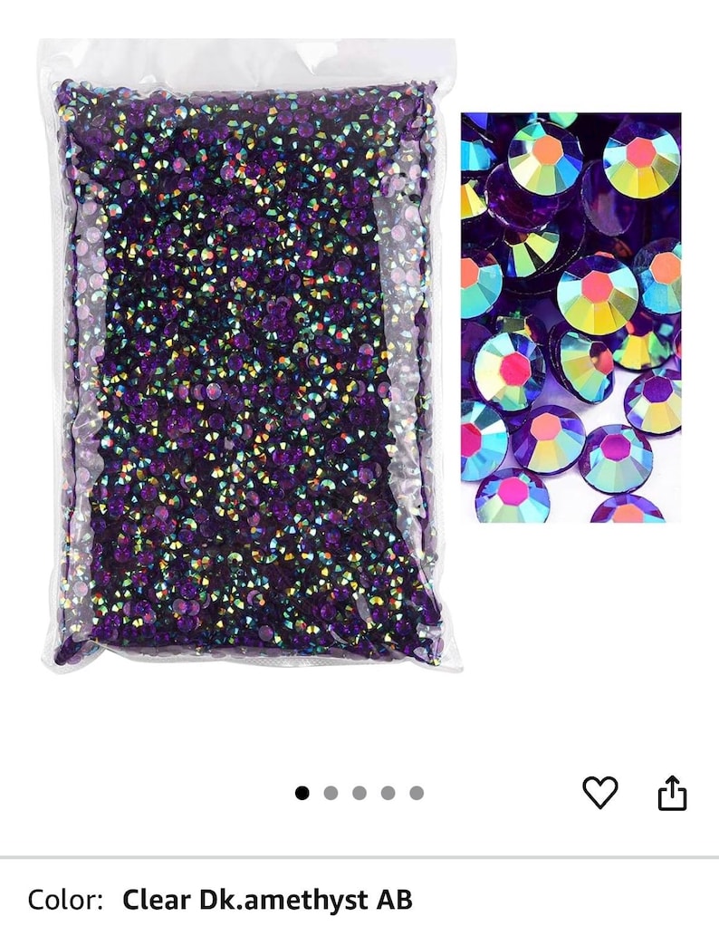 Puede incluir: Una bolsa transparente llena de pedrer&iacute;a Clear Dk.amethyst AB. Las piedras son peque&ntilde;as, redondas y facetadas, con un acabado iridiscente brillante. Un primer plano muestra las variaciones de color de las piedras, incluyendo morado, amarillo y rosa.