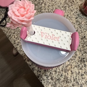 K&ouml;nnte beinhalten: Eine wei&szlig;e Keramik-Tasse mit schwarzem Henkel und dem Text "But First, Coffee" in schwarzer, fetter Schrift. Die Tasse steht auf einer wei&szlig;en Oberfl&auml;che.