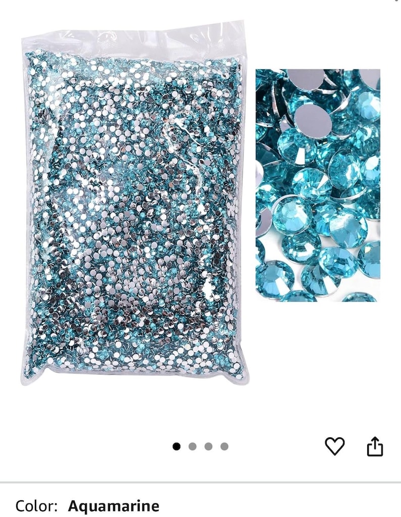 Puede incluir: Una bolsa de pl&aacute;stico transparente llena de pedrer&iacute;a aguamarina. Un primer plano muestra las gemas facetadas, que reflejan la luz. Las piedras de estr&aacute;s son de color azul claro, perfectas para manualidades y adornos.