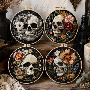 May include: Four circular embroidery hoops featuring detailed thread-stitched human skulls on black fabric. Each skull is surrounded by colourful floral arrangements in shades of white, pink, red, orange, and yellow, framed by wooden hoops.