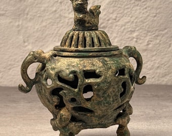 Incensario trípode de metal fundido vintage, remate con forma de animal, acabado patinado, decoración asiática.