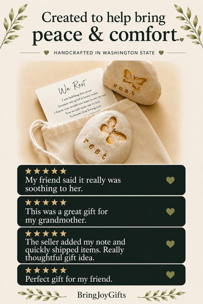 May include: Two smooth, light-colored stones featuring an engraved butterfly and the word "rest," accompanied by a white card with the text "We Rest" and a poem, all placed inside a small, light-colored fabric drawstring pouch.