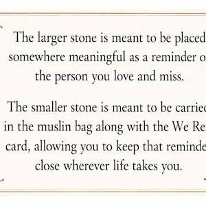 May include: A rectangular card with a cream background and brown leaf illustrations in the corners. The text reads: The larger stone is meant to be placed somewhere meaningful as a reminder of the person you love and miss. The smaller stone is meant to be carried in the muslin bag along with the We Rest card, allowing you to keep that reminder close wherever life takes you.