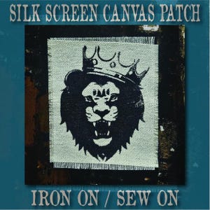 May include: A square canvas patch featuring a black silk screen print of a roaring lion wearing a crown. The patch has frayed edges and the text SILK SCREEN CANVAS PATCH and IRON ON / SEW ON is printed in a serif font above and below the image.