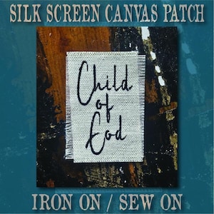 May include: A rectangular off-white canvas patch with frayed edges featuring the black text Child of God in a cursive script. The patch is centred against a dark, textured background with the text SILK SCREEN CANVAS PATCH and IRON ON / SEW ON.