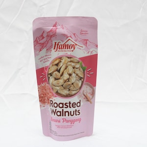 Puede incluir: Una bolsa rosa de nueces tostadas. La bolsa presenta la marca "Ifamoy" y las palabras "Roasted Walnuts" en letras grandes. La bolsa tambi&eacute;n tiene una ilustraci&oacute;n de nueces y una cordillera.