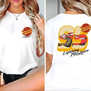 以下が含まれることがあります： 映画「カーズ」のライトニング・マックィーンのグラフィックがプリントされた白いTシャツ。前面には「Rust-eze」と「Lightning McQueen」のロゴ、背面には95の数字と「Lightning McQueen」の文字が描かれています。