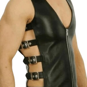 Pu&ograve; includere: Gilet in pelle nera con scollo a V profondo e chiusura con cerniera argentata. Il gilet presenta pi&ugrave; cinturini orizzontali con fibbie argentate sui lati. Un top senza maniche dal design audace.