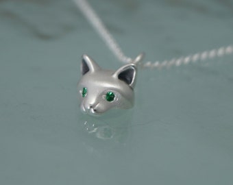 May include: A silver-colored fox head pendant with green gemstone eyes on a delicate silver chain. The fox pendant is detailed with pointed ears and a small nose, creating a charming animal-themed necklace.