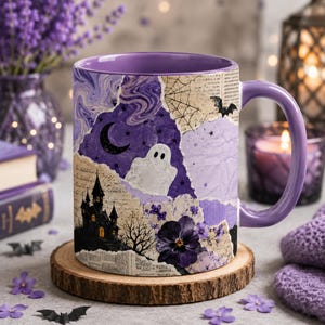 May include: A ceramic mug with a purple interior and handle, featuring a collage design of a haunted house, a white ghost, a crescent moon, a spider web, a bat, and dark purple flowers over a background of vintage script and paper textures.