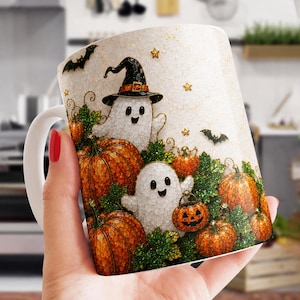 Könnte beinhalten: Ein weißer Keramikbecher mit einem festlichen Halloween-Motiv, das zwei lächelnde Geister zeigt, von denen einer einen schwarzen Hexenhut trägt, umgeben von leuchtend orangefarbenen Kürbissen, grünen Blättern, kleinen goldenen Sternen und schwarzen Fledermäusen.
