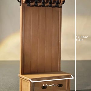 May include: A miniature wooden hall tree with a bench, drawer, and coat hooks. The hall tree is 6.5 inches tall, 3 inches wide, and 1.4 inches deep. It features a light brown finish and is designed for dollhouses or miniature settings.