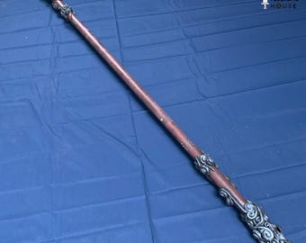 May include: A long, brown staff with ornate silver-colored detailing at both ends. The staff has a dark brown center and is decorated with swirling patterns. The text "FEDERLINE HOUSE" is visible in the upper right corner.