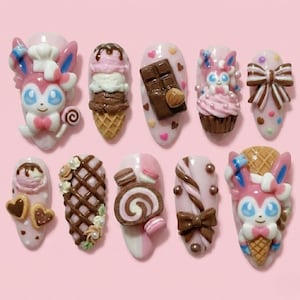 May include: Ten artificial nails with intricate, colourful designs. The nails showcase dessert-themed decorations such as ice cream cones, chocolate bars, cupcakes, bows, and character figures. The designs are set against a pink backdrop, creating a sweet and playful aesthetic.