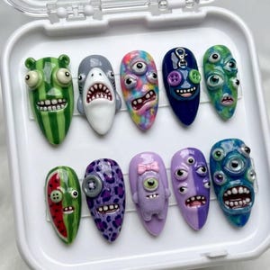 Unghie finte fatte a mano con mostri inquietanti ma carini, unghie finte personalizzate con personaggi divertenti in 3D, design estetico horror stravagante, unghie con creature surreali