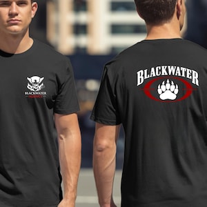 May include: Black t-shirts with the "Blackwater Agency" logo on the front and the "Blackwater" logo with a paw print design on the back. The front logo features a stylized eagle and shield design. The back logo is in white and red.