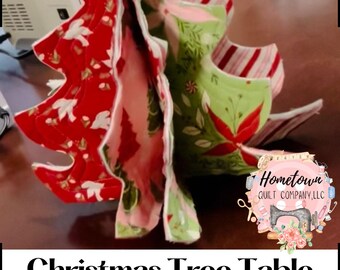 Könnte beinhalten: Eine Vorlage für eine Weihnachtsbaum-Tischdekoration aus Stoffschichten. Der Baum hat roten Stoff mit weißen Akzenten, grünen Stoff mit floralen Mustern und rosa Stoff. Der Text "Christmas Tree Table Decoration Template" ist im Bild enthalten.