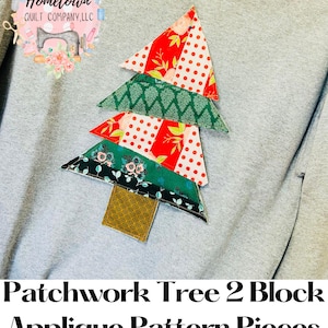May include: Patchwork Tree 2 Block Applique Pattern Pieces. A gray sweatshirt with a colorful patchwork tree applique. The tree is made of different fabrics with red, green, white, and black patterns.