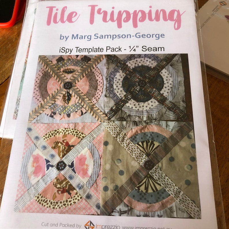 May include: A quilting pattern template pack called "Tile Tripping" by Marg Sampson-George. The pack includes templates for making a quilt with a geometric design using 1/4 inch seams. The quilt is made of fabric scraps in shades of brown, pink, blue, and white.