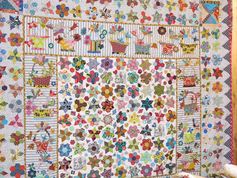 May include: A colorful quilt with a patchwork design featuring stars, flowers, and baskets. The quilt is made with a variety of fabrics in bright colors and patterns.