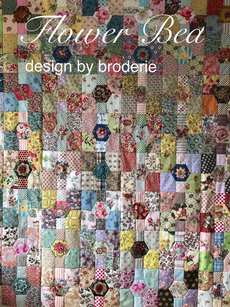 K&ouml;nnte beinhalten: Ein farbenfroher Quilt mit einem Blumenmuster. Der Quilt besteht aus vielen verschiedenen Quadraten, jedes mit einem anderen Blumendesign. Der Quilt tr&auml;gt den Titel "Flower Bed" und sagt "design by broderie".