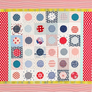 Könnte beinhalten: Eine weiße Steppdecke mit Patchwork-Muster, das rote, blaue und weiße Kreise auf weißem Hintergrund zeigt. Die Steppdecke ist mit roten und weißen Streifen und einem gelben und weißen Streifenrand eingefasst.