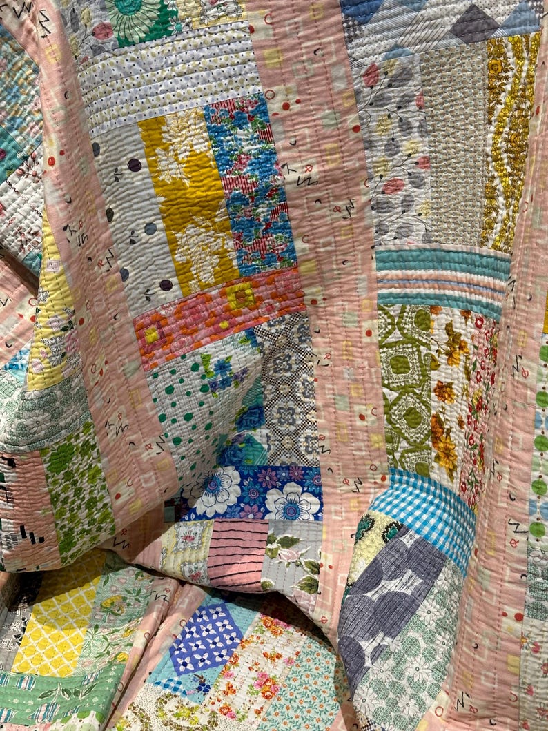Puede incluir: Una colcha de retazos con una variedad de patrones florales y geom&eacute;tricos en tonos de rosa, azul, verde y amarillo. La colcha est&aacute; hecha de diferentes telas y texturas, creando un dise&ntilde;o &uacute;nico y colorido.