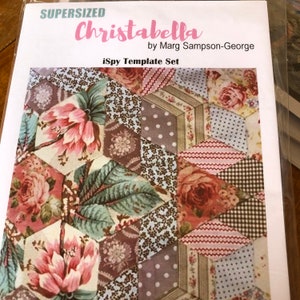 May include: A quilting pattern template set called "Supersized Christabella" by Marg Sampson-George. The pattern features a hexagonal design with floral and geometric fabric prints in shades of pink, brown, green, and blue.