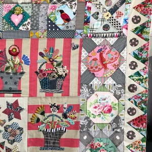 May include: A patchwork quilt with a floral theme. The quilt is made up of different fabrics and patterns, including stripes, polka dots, and flowers. The quilt is bordered with a scalloped edge.