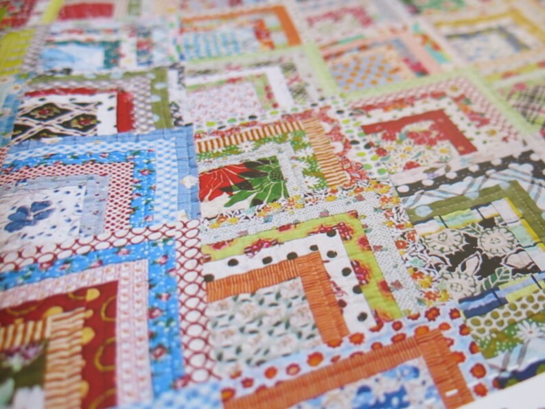 May include: A patchwork quilt with a variety of colorful fabrics and patterns. The quilt is made up of squares and rectangles, and the seams are visible. The quilt is a mix of floral, geometric, and polka dot patterns.