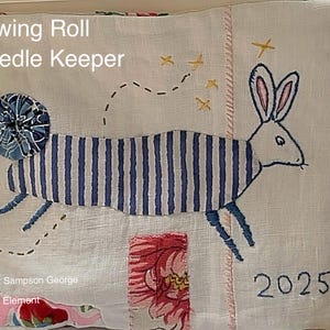 May include: A white fabric needle keeper with a blue and white striped rabbit, a blue and white polka dot circle, and the text "Sewing Roll Needle Keeper" and "2025".