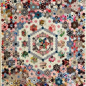 May include: A colourful quilt featuring a geometric pattern of hexagons and stars. The quilt is made from a variety of fabrics with floral and geometric prints in shades of pink, blue, red, brown and white.