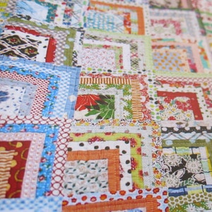 May include: A colorful quilt made with a patchwork of different fabrics. The quilt is made up of squares of various sizes and colors, with a variety of patterns and textures. The quilt is a beautiful example of handmade craftsmanship.