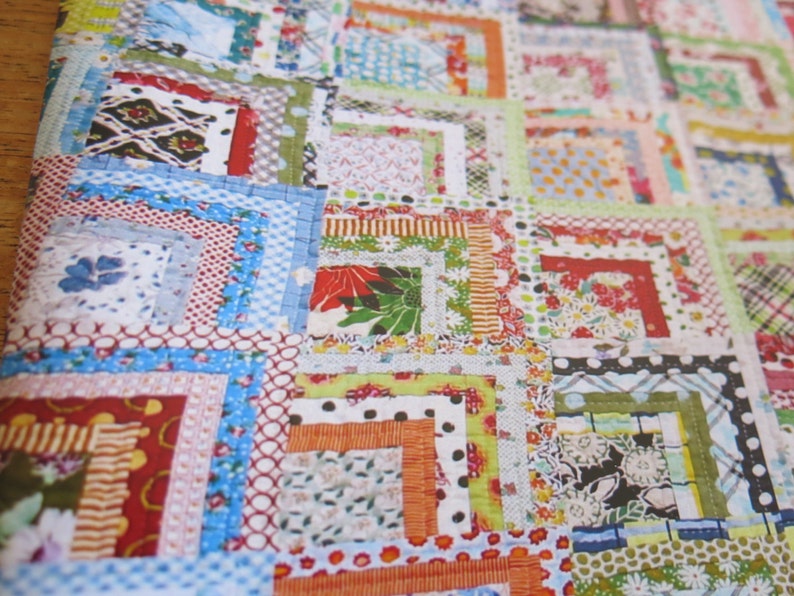 May include: A colorful quilt made with a patchwork of different fabrics. The quilt is made up of squares of various sizes and colors, with a variety of patterns and textures. The quilt is a beautiful example of handmade craftsmanship.