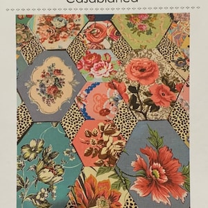 May include: A colorful patchwork quilt with floral patterns in shades of red, pink, blue, and green. The quilt features hexagonal shapes with a leopard print accent. The text "Casablanca" is visible.