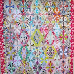 May include: A colorful quilt with a geometric pattern of repeating flower shapes. The quilt is made of various fabrics with different patterns and colors, including pink, blue, green, yellow, and white.