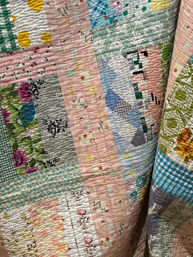 Puede incluir: Una colcha de retazos con una variedad de patrones florales y geom&eacute;tricos en tonos de rosa, azul, verde y blanco. La colcha est&aacute; hecha de diferentes telas y texturas, creando un dise&ntilde;o &uacute;nico e interesante.