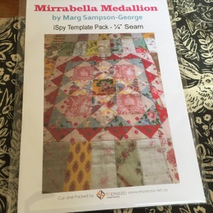 May include: A close-up of a printed pattern for a quilt called "Mirrabella Medallion" by Marg Sampson-George. The pattern is for a quilt with a red, white, and blue color scheme. The pattern is for a quilt with a 1/4 inch seam allowance. The pattern is cut and packed by Imprezzio.