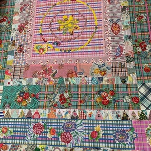 Peut inclure: Une courtepointe patchwork avec une variété de motifs floraux et de couleurs, notamment le rose, le vert, le bleu et le jaune. La courtepointe est composée de différents carrés et rectangles de tissu, cousus ensemble pour créer un design unique.