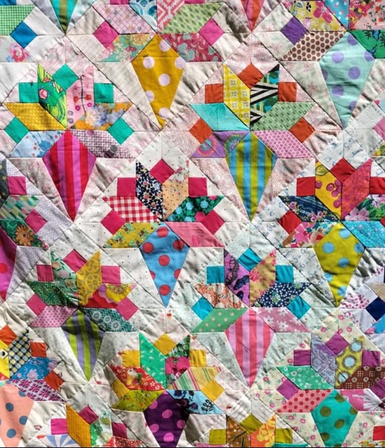May include: A colorful patchwork quilt with a variety of fabrics and patterns. The quilt is made up of squares and triangles, and the colors are bright and cheerful.