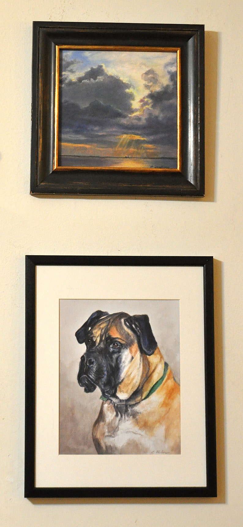 May include: A framed painting of a dog, a Bullmastiff, with a green collar. The dog is looking to the left of the image. The painting is in a black frame with a white mat.