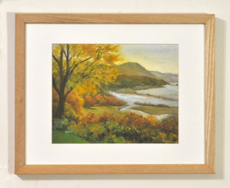 Puede incluir: Una pintura enmarcada de una escena de paisaje con un r&iacute;o serpenteando a trav&eacute;s de un bosque. Los &aacute;rboles est&aacute;n en tonos de amarillo, naranja y verde, y el r&iacute;o es de un azul claro. El cielo es de un gris p&aacute;lido.