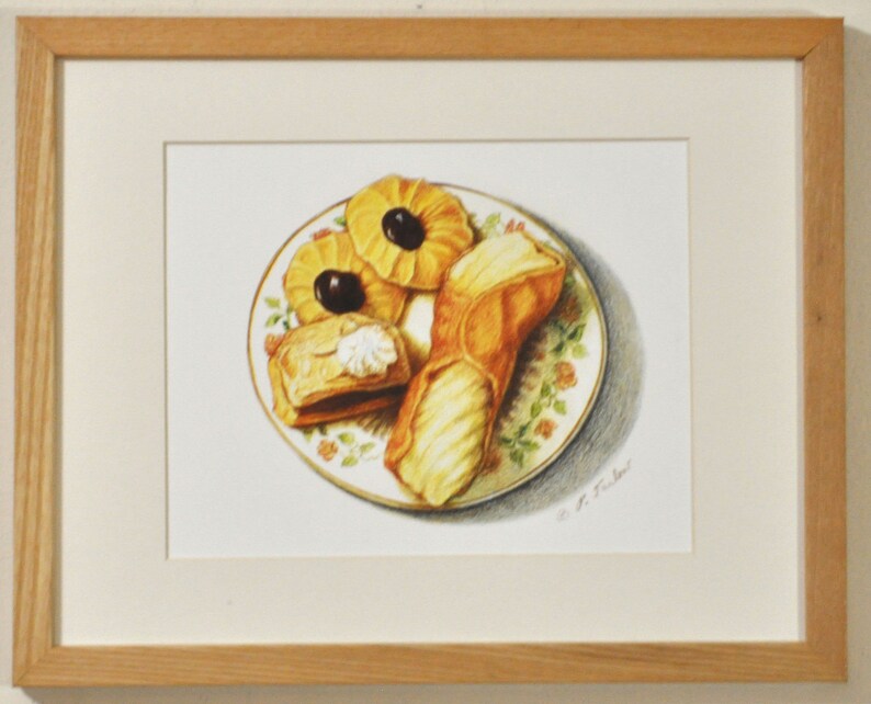 May include: A framed drawing of a plate of pastries. The plate has a floral pattern and contains three pastries: a cannoli, a puff pastry with a dollop of cream, and two round cookies with black olives on top.