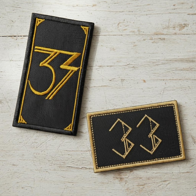 May include: Two black embroidered patches with the number "33" in gold. One patch is rectangular with a gold border and the other is a vertical rectangle with a gold border and gold number.