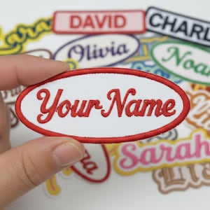 May include: A white oval patch with red trim and the text "Your Name" in red script is held in a hand. Other name patches are in the background, including "David", "Olivia", and "Noah".