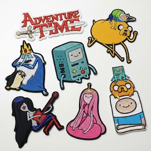 May include: A collection of Adventure Time embroidered patches featuring characters like Finn, Jake, BMO, Princess Bubblegum, and others. The patches are colorful and include the show's logo with a sword.
