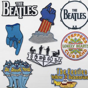 May include: A collection of embroidered patches featuring The Beatles. Designs include the band's logo, a drum, a hand pointing upwards, and imagery from the "Yellow Submarine" film. Other patches include the "Help!" album title and the "Sgt. Pepper's Lonely Hearts Club Band" logo.