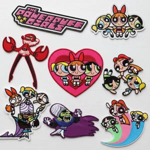 May include: A collection of embroidered patches featuring characters and logos from "The Powerpuff Girls" cartoon. Designs include the show's logo, the three main characters, and villains. Patches are in various shapes and colors, suitable for clothing or accessories.